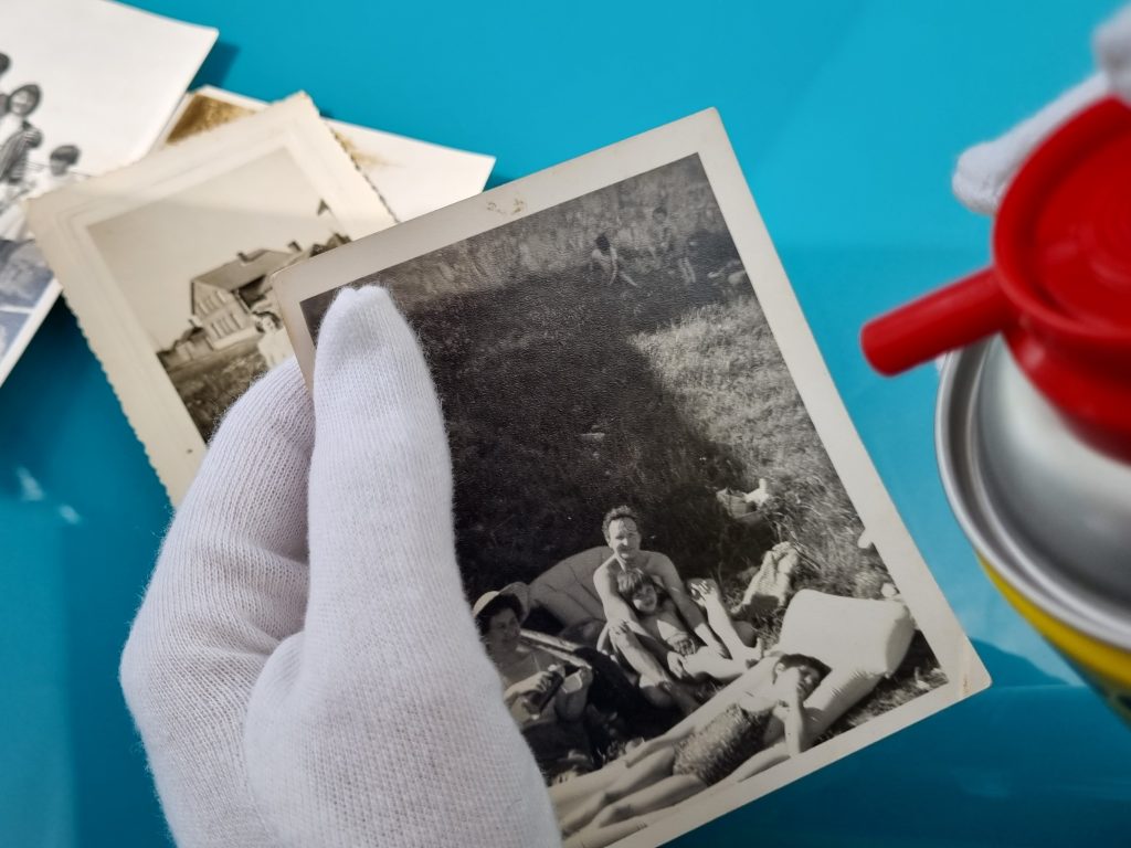 Image of hand wearing a white glove holding a photo applying spray.
