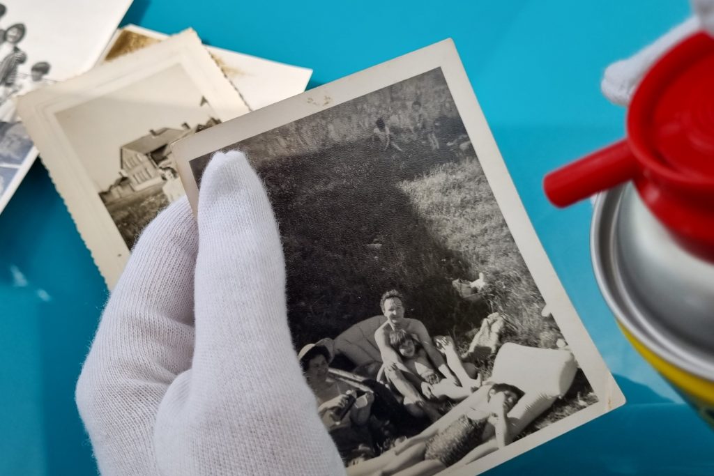 air pressure cleaner being pointed at some old photographs