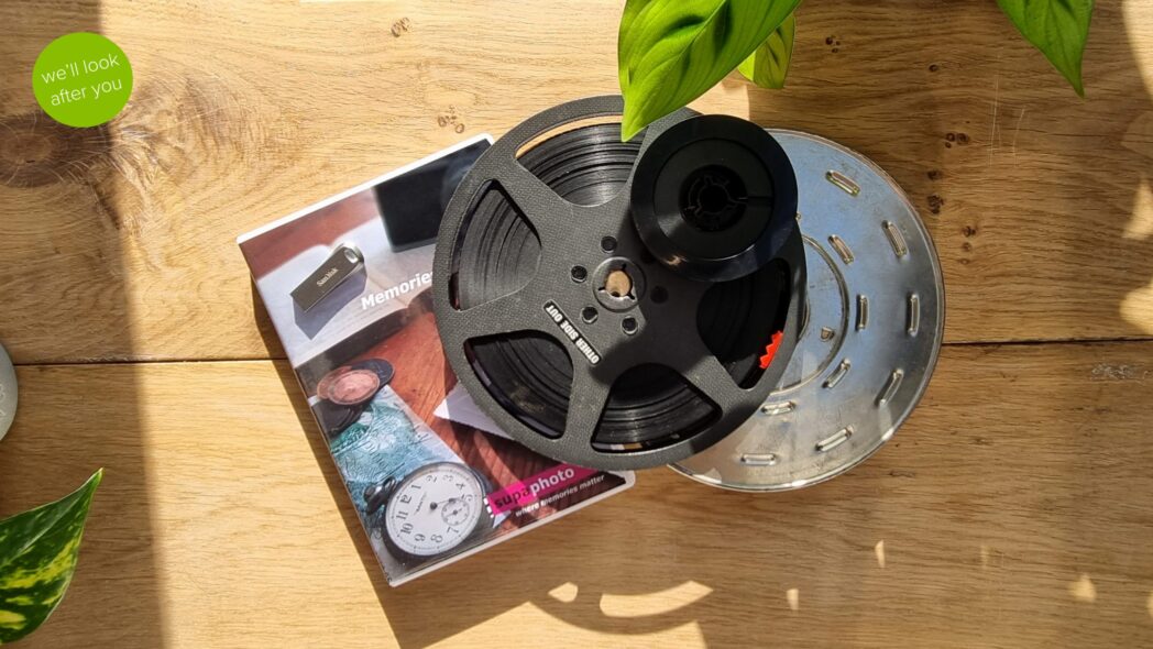 a collection of cine film reels with a dvd case and a memory stick on a woody and leafy background