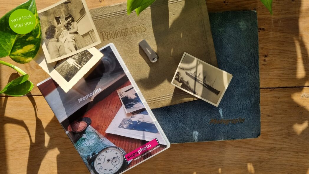 Vintage photo albums, photos that need restoring over them, a memory stick and a dvd case