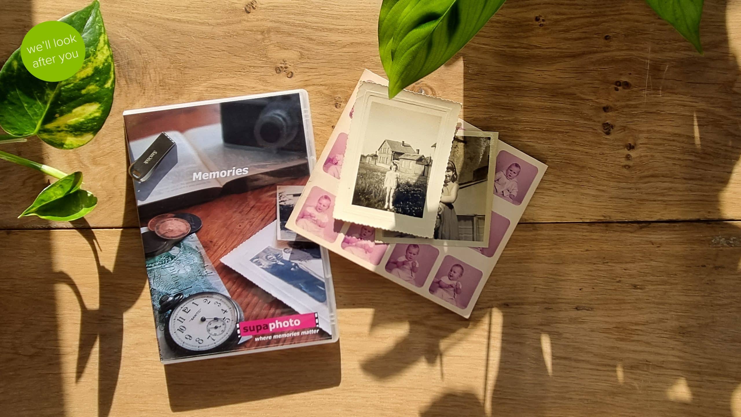 vintage photographs in need of enhancing on a wooden background with dvd case and memory stick