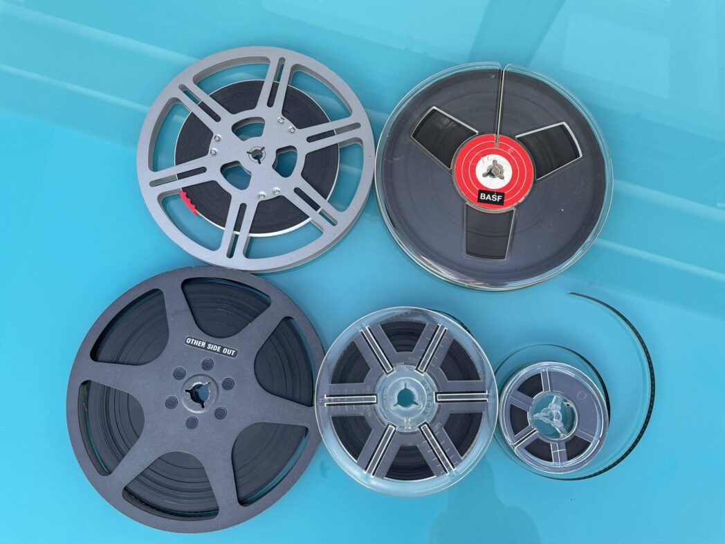Different sizes of cine film reels on a blue background