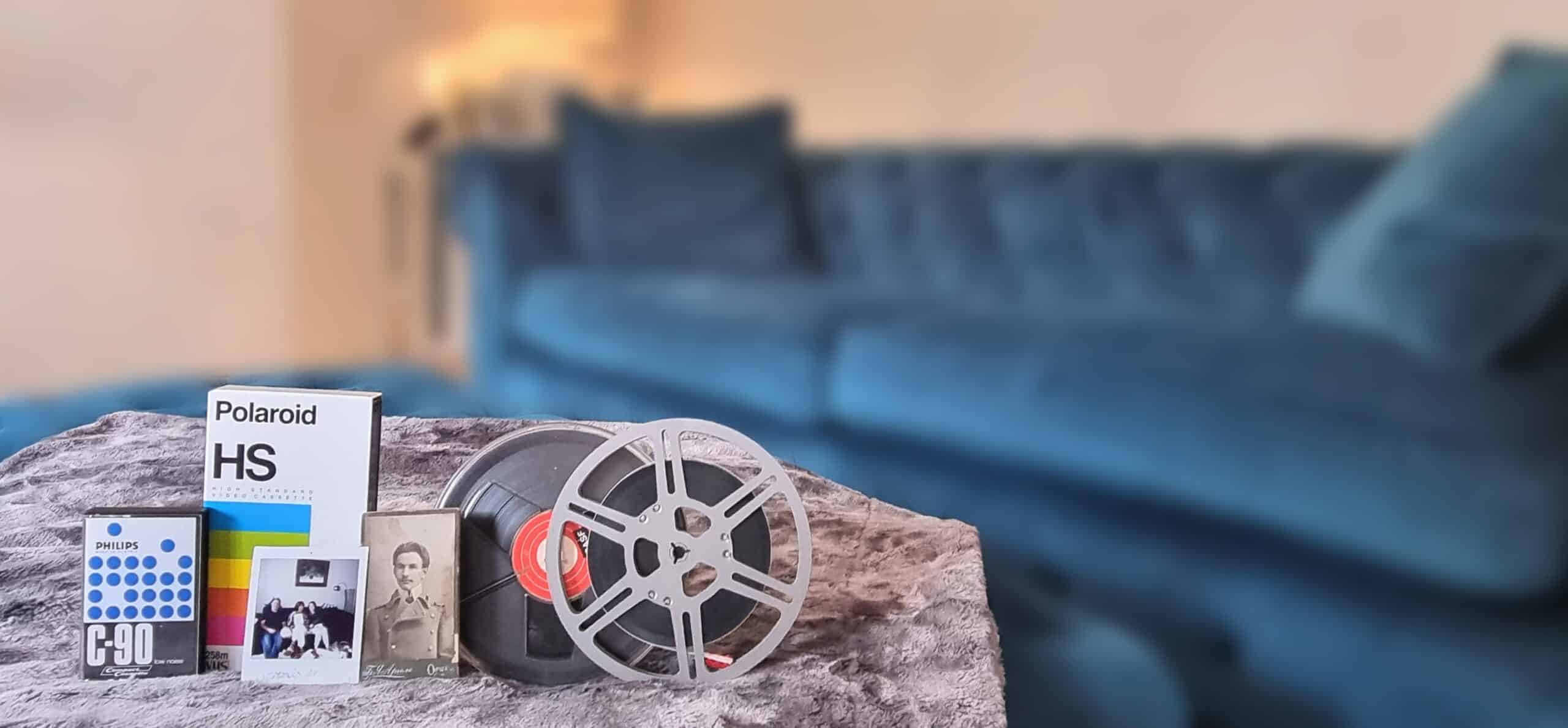 A collection of Cine Film, VHS Tapes and Cassettes on a sofa blue sofa.