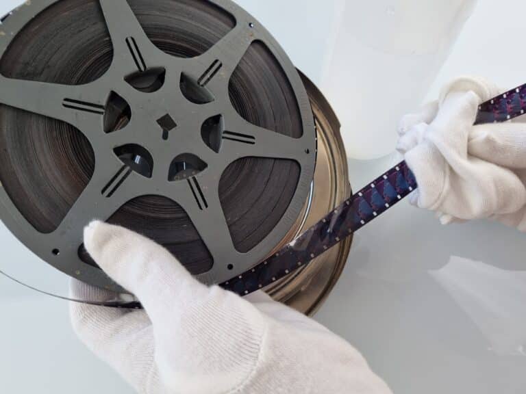 to help understand what kind of film do i have - a 16mm cine reel being gently handled by someone with gloves