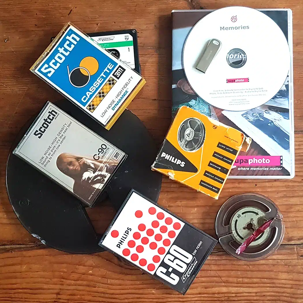 Audio cassette and reel to reel magnetic tape with DVD Case & USB on a table - Convert audio tapes to digital service