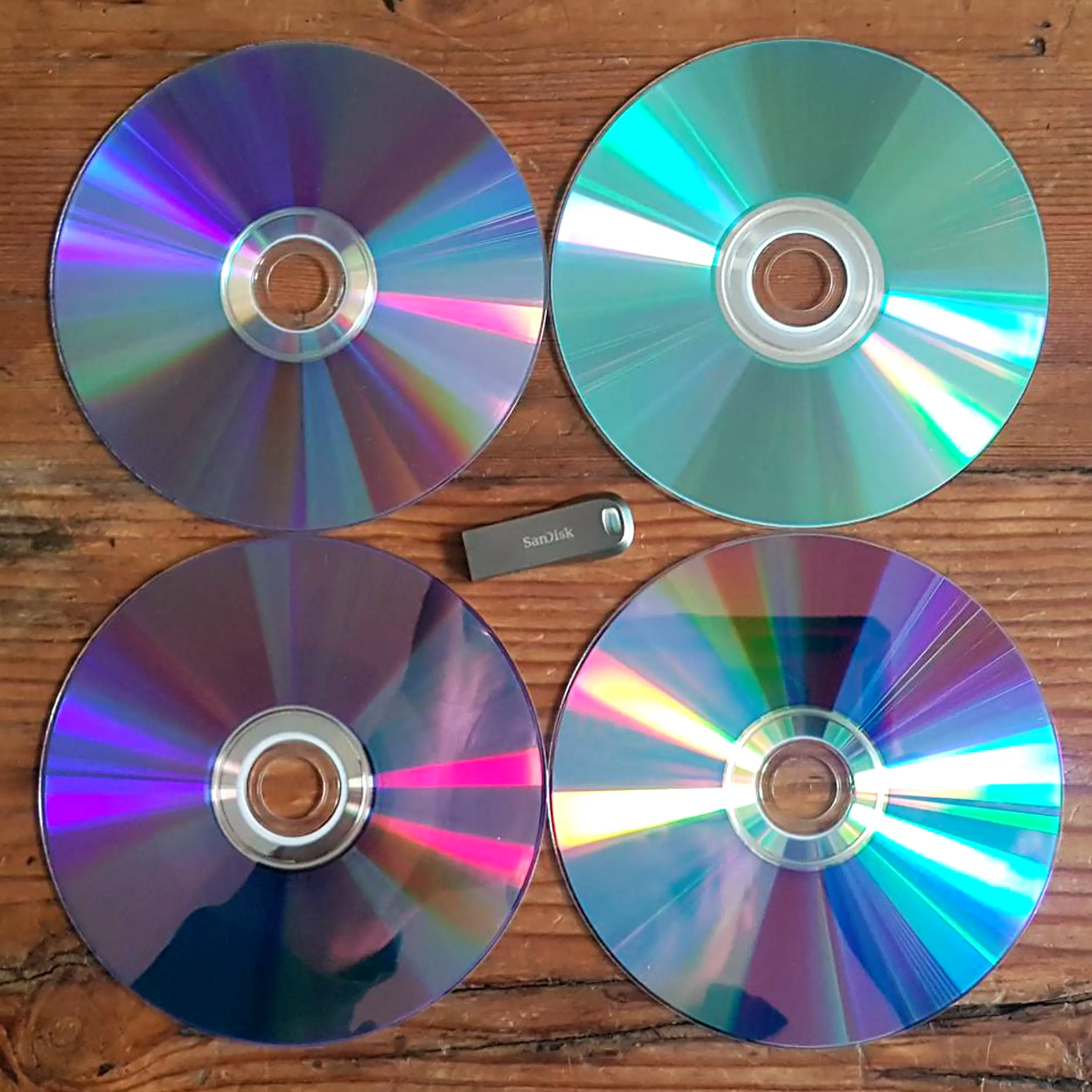 A close up of different types of Disc including DVDs and CDs with & USB Memory Stick