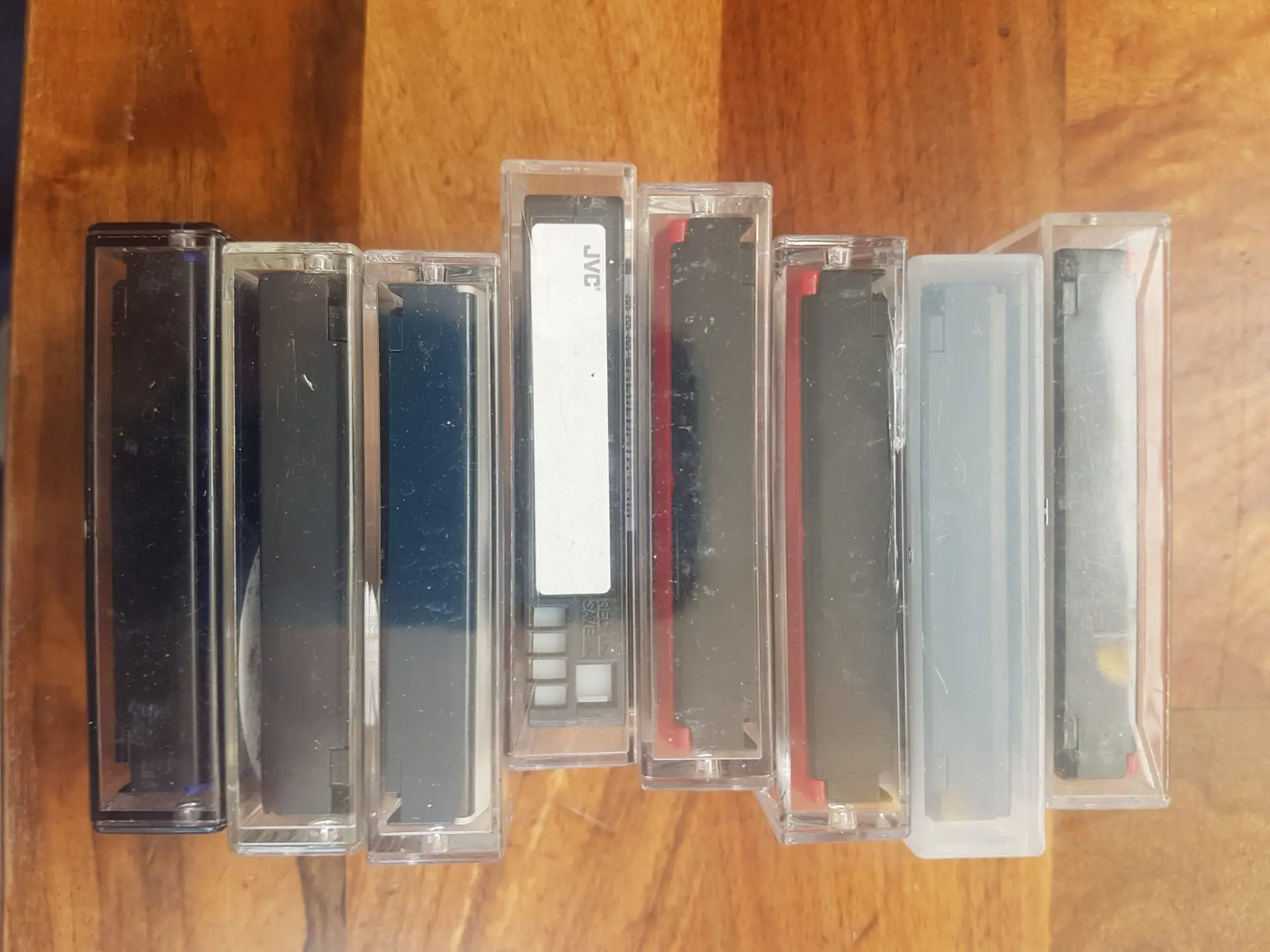 Camcorder tapes stacked along wooden table