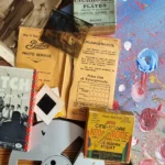 A collection of vintage photographic materials and media, including negatives, slides, film reels, and archival paperwork arranged on a table.