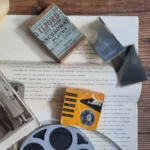 Vintage photographic materials, film reels, negatives, and documents arranged on a wooden table.