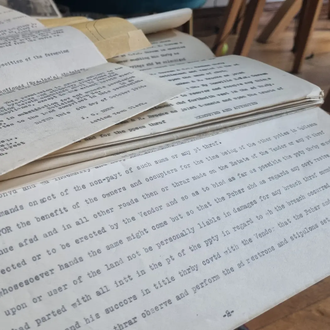 Stack of old typed archival documents with visible text and worn paper edges.