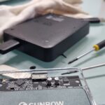 External storage device and disassembled SSD enclosure on a desk with screwdrivers, used for data conversion and duplication.